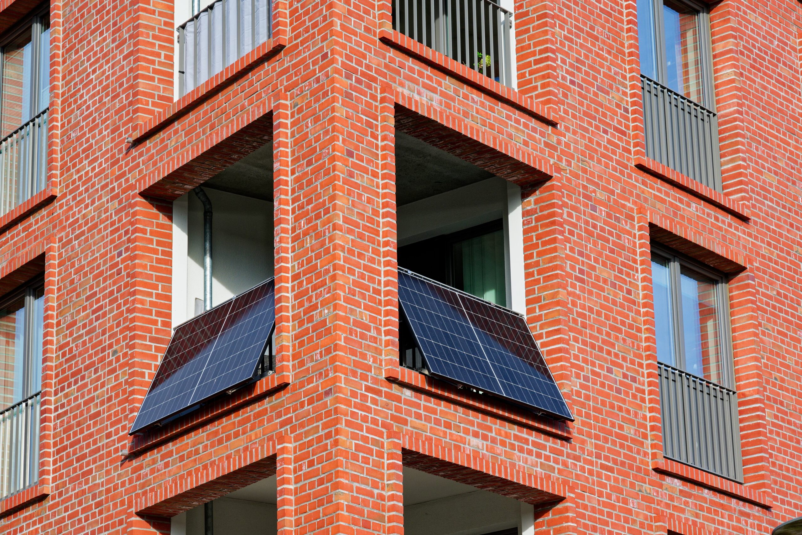 Solarmodul am Balkon eines roten Backsteingebäudes